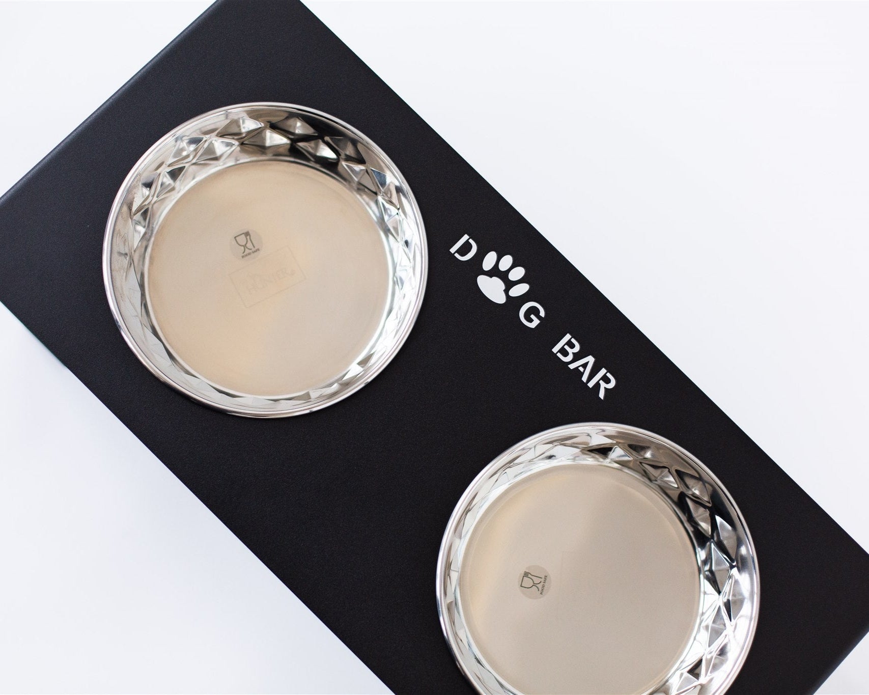 Two silver dog bowls on a black box with 'Dog Bar' branding.