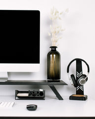 Modern office desk setup with computer monitor, keyboard, mouse, and decorative items.