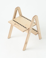 Wooden step stool with black wavy lines on a white background