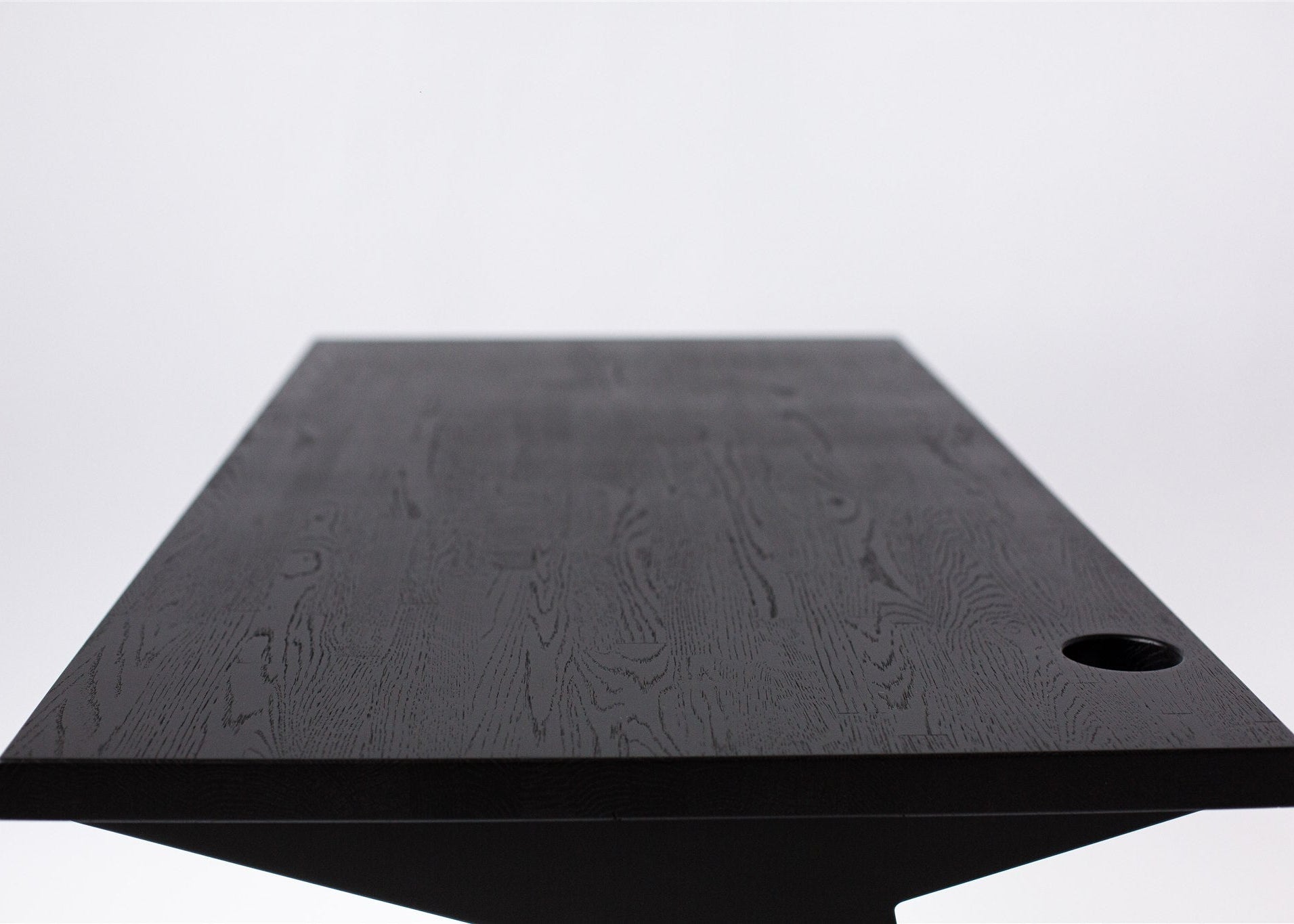 Black table with a textured surface on a light gray background