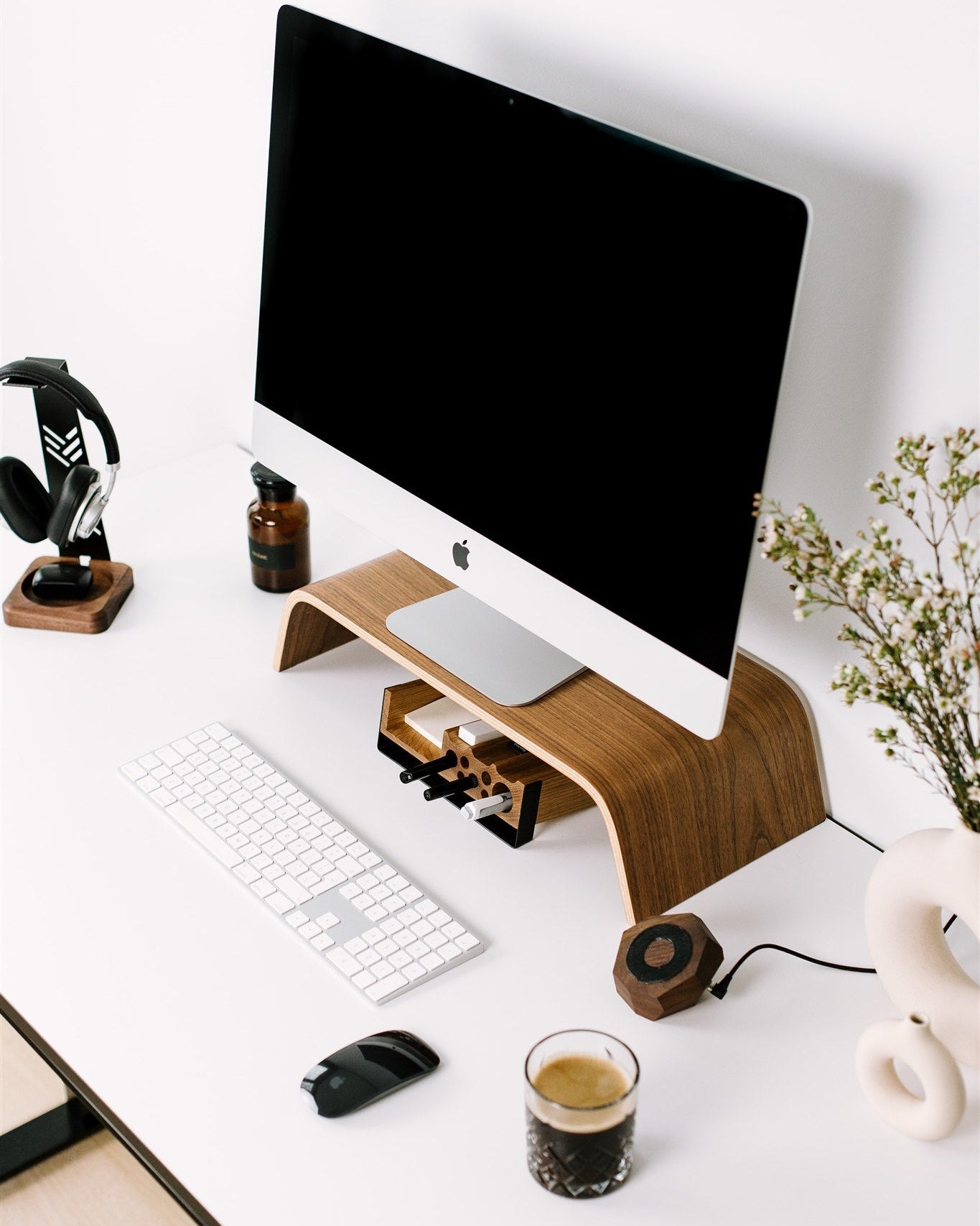 Modern office desk setup with computer monitor, keyboard, mouse, and coffee cup.