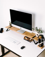 Modern home office desk setup with computer monitor, keyboard, mouse, and headphones on a white background.