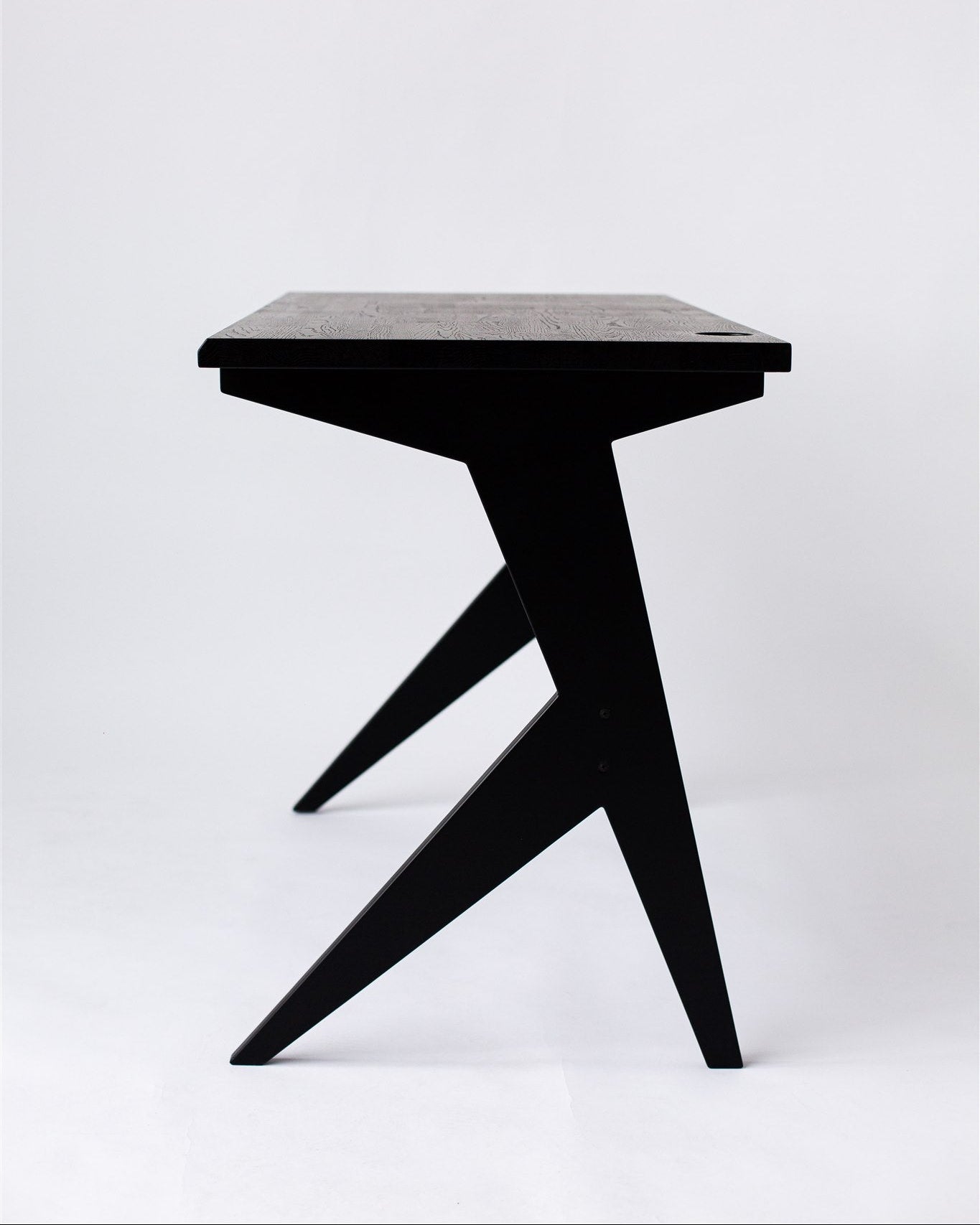 Black side table with a minimalist design on a white background