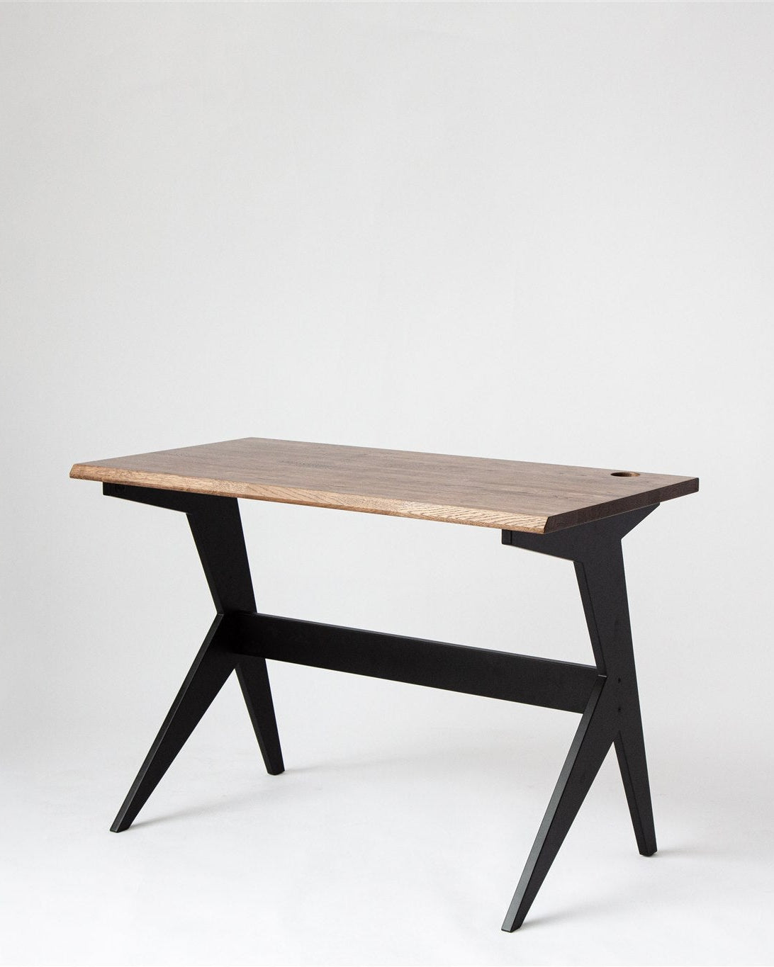 Wooden table with black design legs on a white background