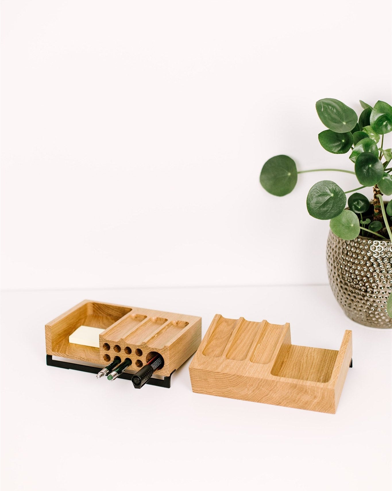 Oak desk organizer with compartments on a white surface with a plant in the background