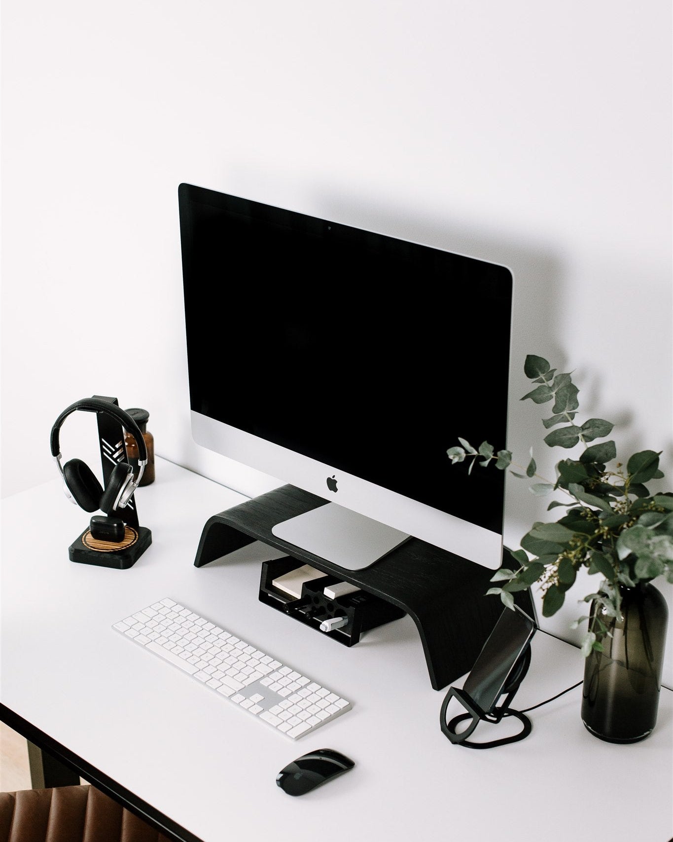 Modern office desk setup with computer monitor, keyboard, mouse, and decorative elements.