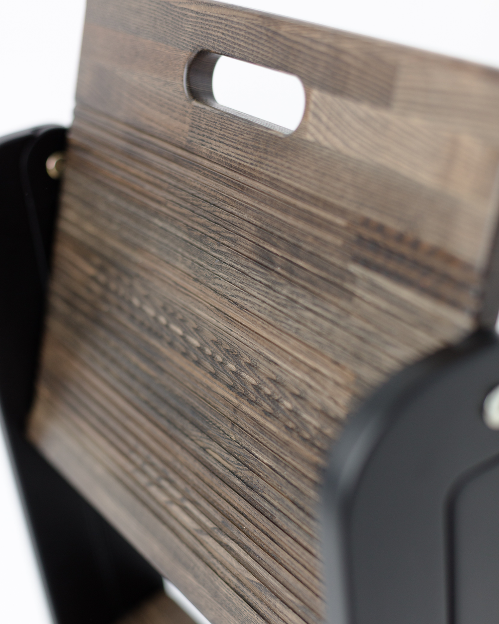 Close-up of a wooden surface with a black object partially visible
