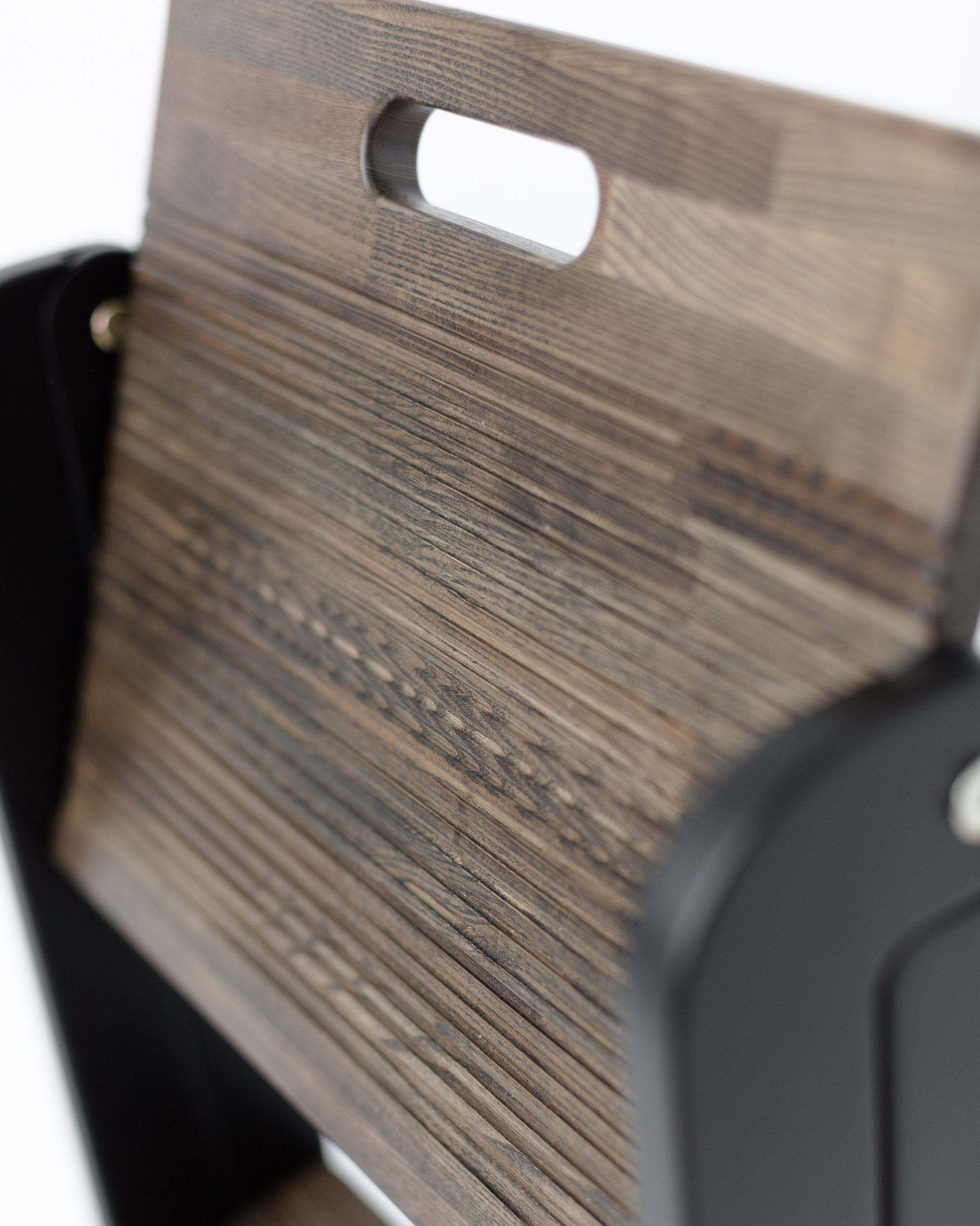 Close-up of a wooden surface with a black object partially visible