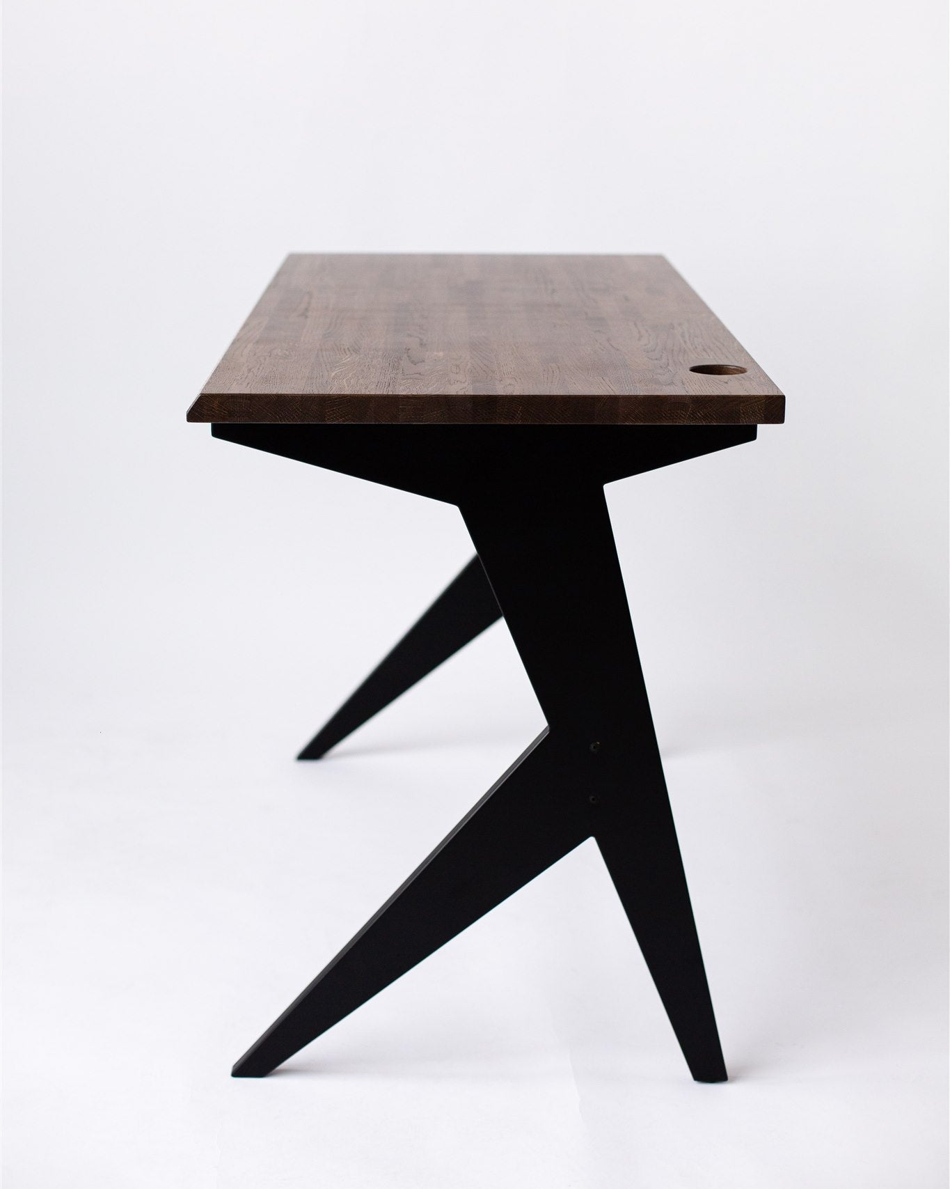 Wooden table with black design legs on a white background