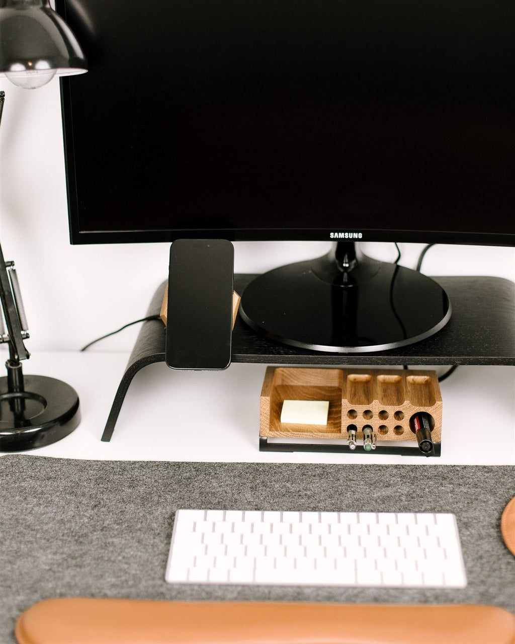 Computer monitor, keyboard, and mouse on a desk with a lamp and small wooden box.
