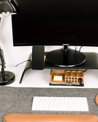 Computer monitor, keyboard, and mouse on a desk with a lamp and small wooden box.