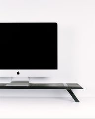 Black computer monitor on a white desk with a white wall background