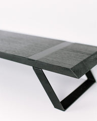 Modern black metal monitor stand with a wooden base on a white background