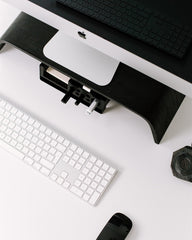 White desk with computer monitor, keyboard, mouse, and smartphone on a white background