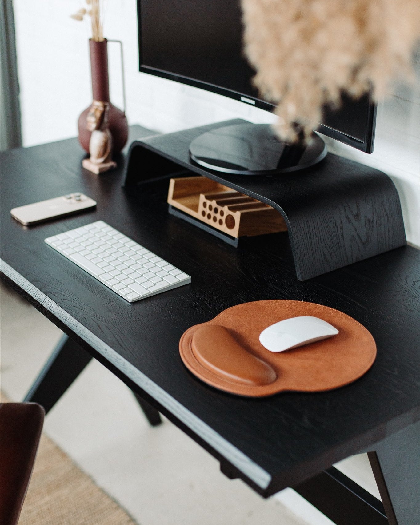 Modern office desk with computer setup, keyboard, mouse, and decorative items.