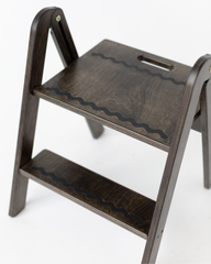 Wooden step stool with wavy pattern on a white background
