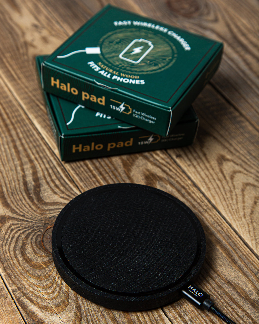 Black Halo pad wireless charging pad with packaging on a wooden surface