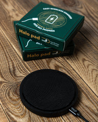 Black Halo pad wireless charging pad with packaging on a wooden surface