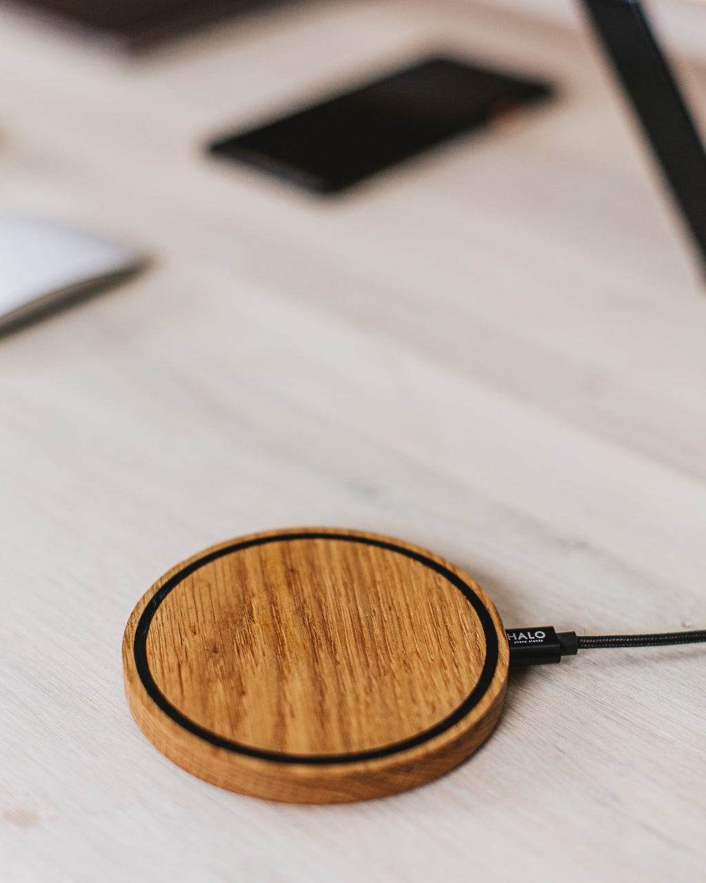 Wooden wireless charging pad on a light wooden surface