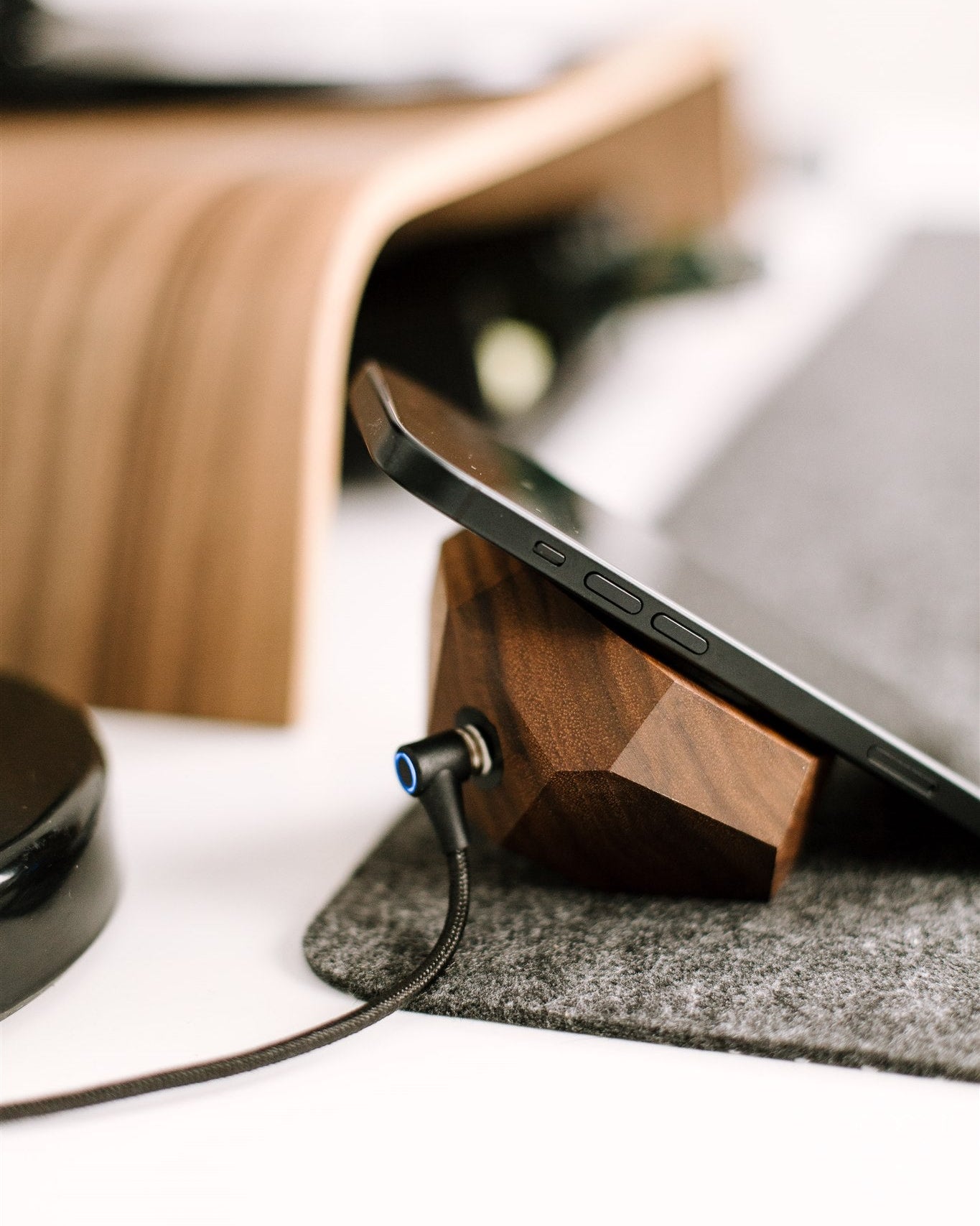 Smartphone with wireless charger on a wooden stand on a desk